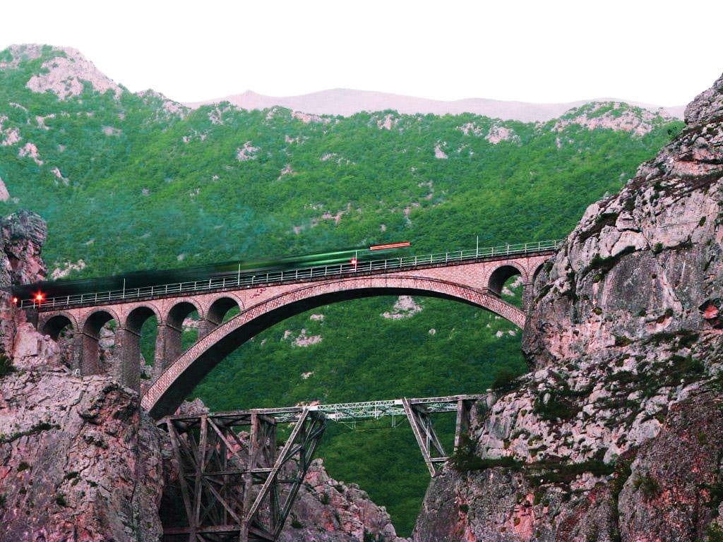 A Train Crosses The Iconic Veresk Bridge In Northern Iran, A Marvel Of Engineering Set Against A Stunning Natural Backdrop.