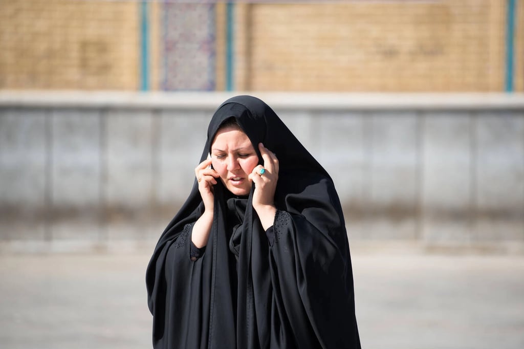 A Woman In A Black Chador Speaks On The Phone While Visiting Qom, Iran, Blending Traditional Attire With Modern Communication In The Heart Of One Of The Country’s Most Religious Cities. Having An Iran Travel Sim Card Ensures She Stays Connected Effortlessly During Her Travels. Contributor: Roberto Cornacchia / Alamy Stock Photo